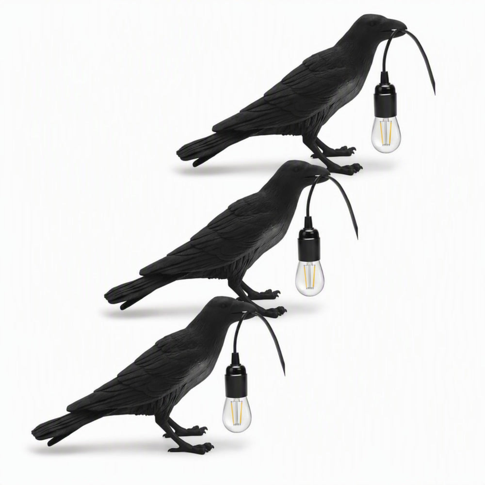 Black raven lamp on a dark moody shelf with candles and books