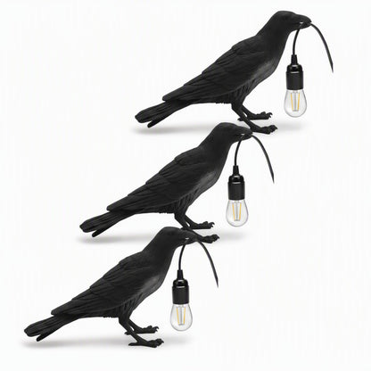 Black raven lamp on a dark moody shelf with candles and books